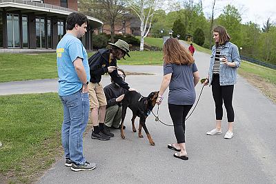 外面的一群学生聚集在其中一只治疗犬周围，给予她关注. 